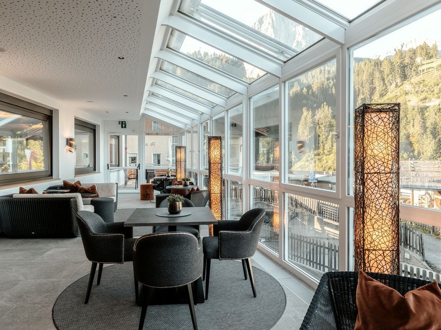 Der Place to be für deinen Urlaub in Gröden Modern eingerichteter Wintergarten mit Sitzgruppen und Bergblick