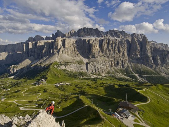 Dolomiten + Wandern + Hotel Cristallo = hallo Sommer! Kletterer vor den Dolomiten und grünen Wiesen im Sommer