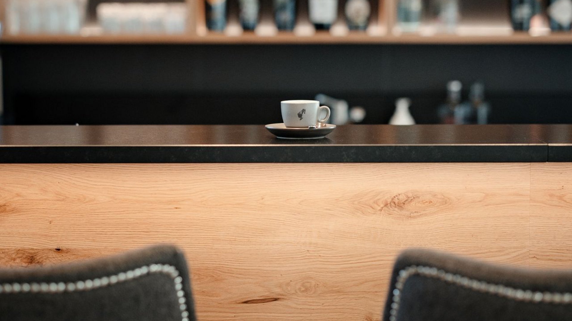 La tua vacanza in Val Gardena è qui Area bar vuota con due sgabelli e una tazza di caffè sul banco