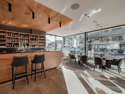 Hotel in St. Christina, Gröden: your mountain escape Modern bar with wooden ceiling and sunlight through large windows