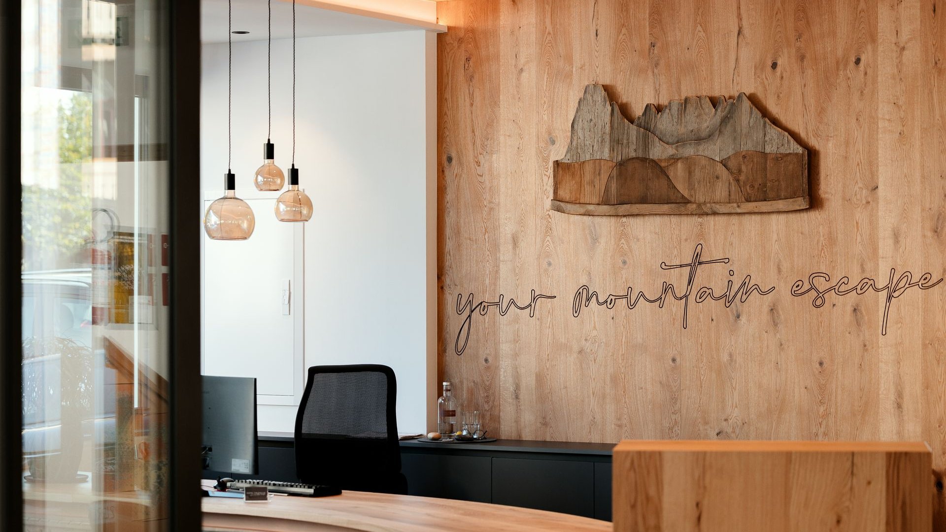 Modern wooden reception with mountain decoration and text your mountain escape
