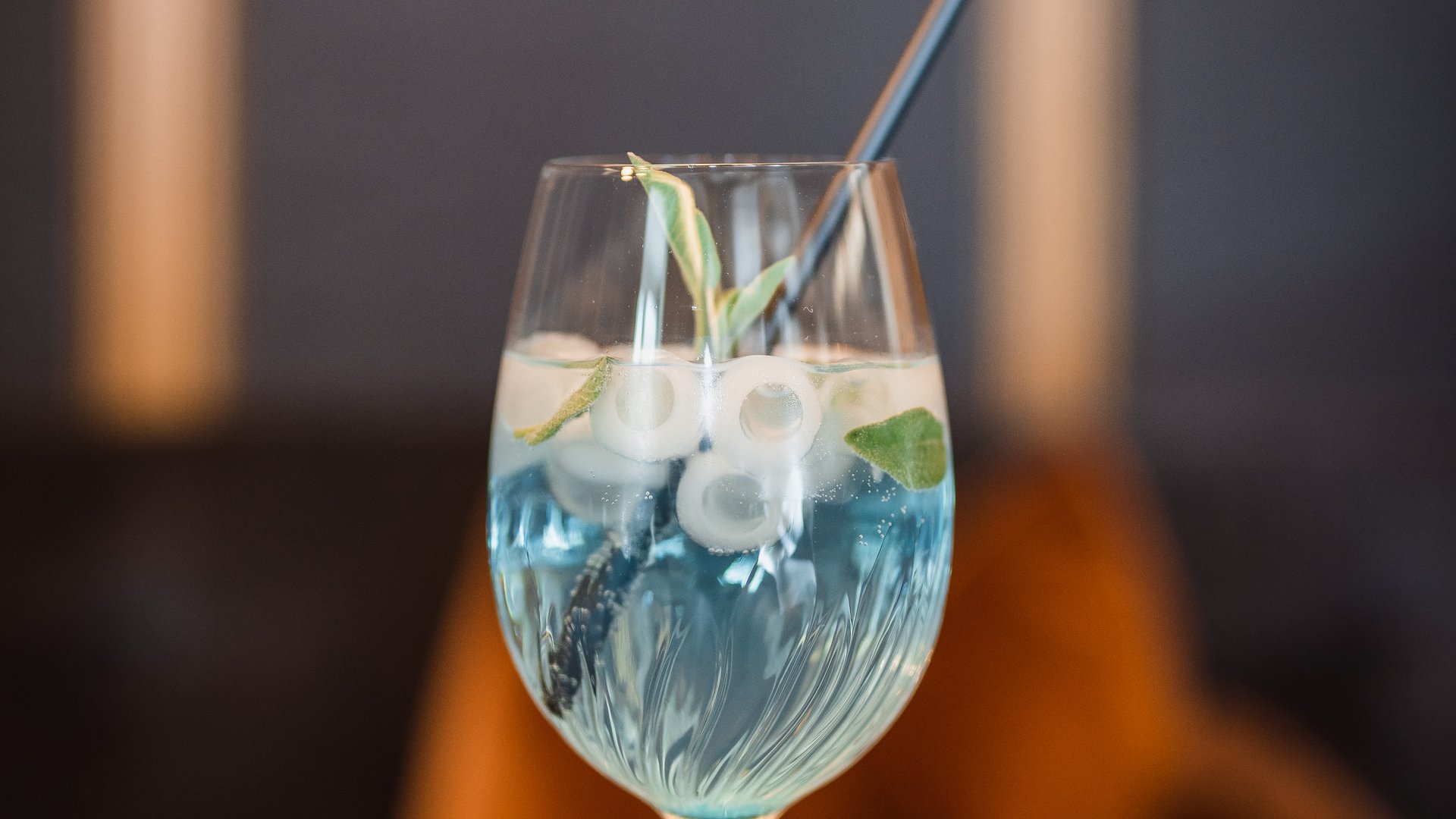 La tua vacanza in Val Gardena è qui Cocktail blu con ghiaccio, menta e cannuccia in bicchiere da vino
