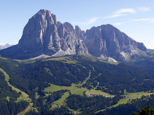 Dolomiten + Wandern + Hotel Cristallo = hallo Sommer! Felsen und grüne Almwiesen in einem Bergtal unter blauem Himmel