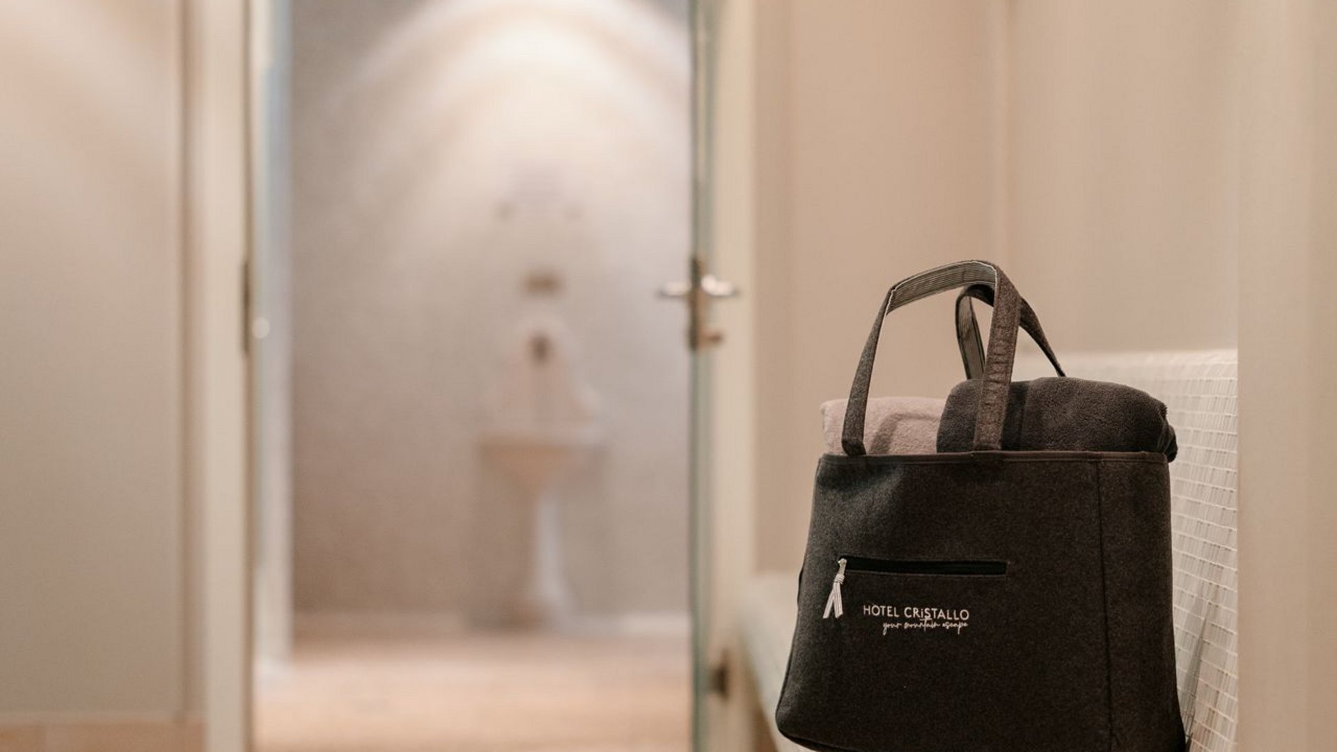 South Tyrol hotel with pool (3 stars): right here! Sauna area with open glass door, bag on bench and slippers on the floor