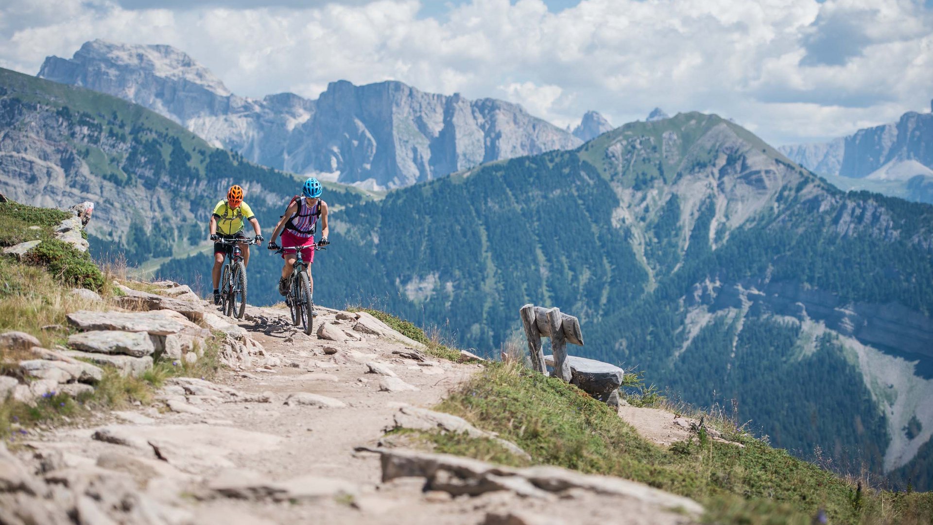 Dolomiten + Wandern + Hotel Cristallo = hallo Sommer! Zwei Mountainbiker fahren auf einem Bergpfad in den Alpen
