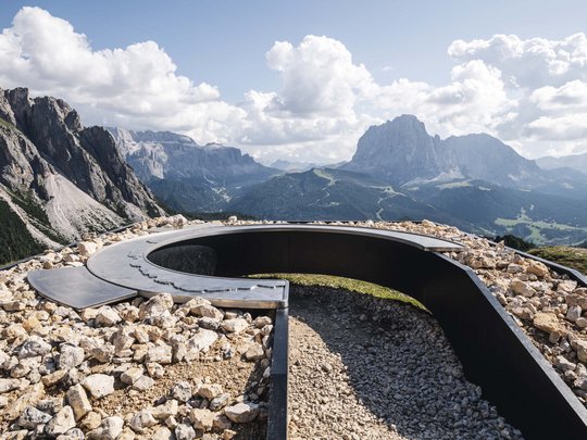 Dolomiten + Wandern + Hotel Cristallo = hallo Sommer! Aussichtspunkt mit Modell und Blick auf Berge bei bewölktem Himmel
