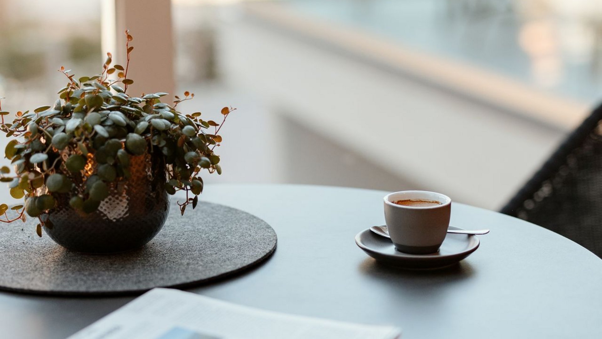 Hotel a Santa Cristina, Val Gardena, con mezza pensione Tazza di caffè, giornale e pianta su tavolo rotondo vicino alla finestra