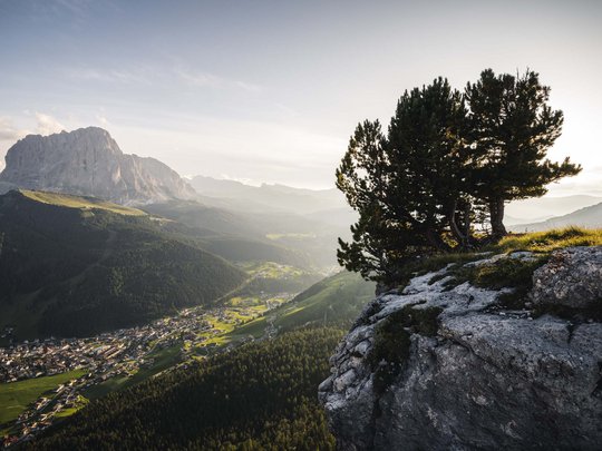 Dolomiten + Wandern + Hotel Cristallo = hallo Sommer! Blick von einem Felsen auf ein Dorf mit Bergen und Wald im Hintergrund