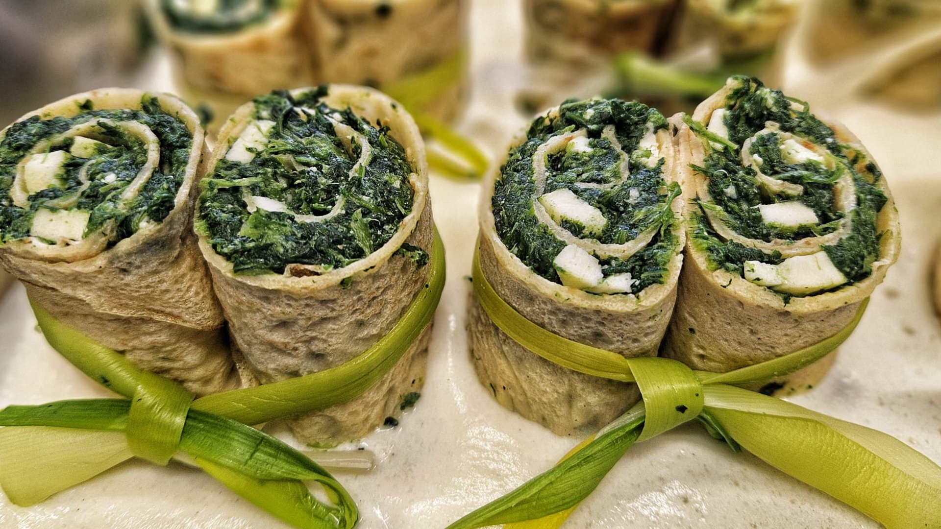 Cuisine at one of the top hotels in Grödnertal with 3 stars Vegetarian spinach and cream cheese rolls tied with green onion on creamy sauce