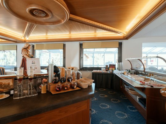 Cuisine at one of the top hotels in Grödnertal with 3 stars Breakfast buffet with cereal, jams, and cold cuts in cozy dining area