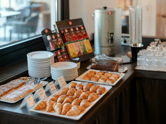 Cuisine at one of the top hotels in Grödnertal with 3 stars Buffet with croissants, pastries, tea bags, glasses, and plates