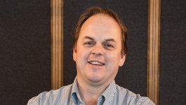 Il nostro hotel a Santa Cristina e i suoi proprietari Uomo sorridente con le braccia incrociate davanti a sfondo scuro