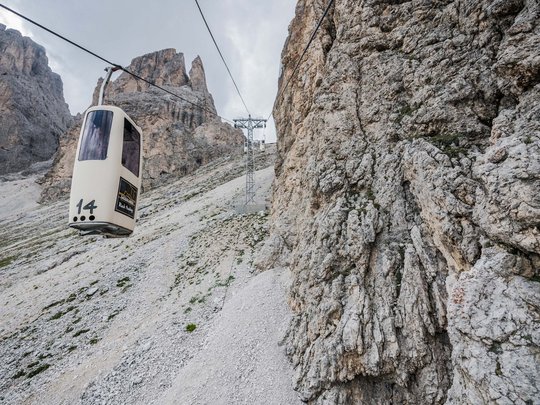 Dolomiten + Wandern + Hotel Cristallo = hallo Sommer! Eine Seilbahn fährt über felsiges und steiniges Bergterrain