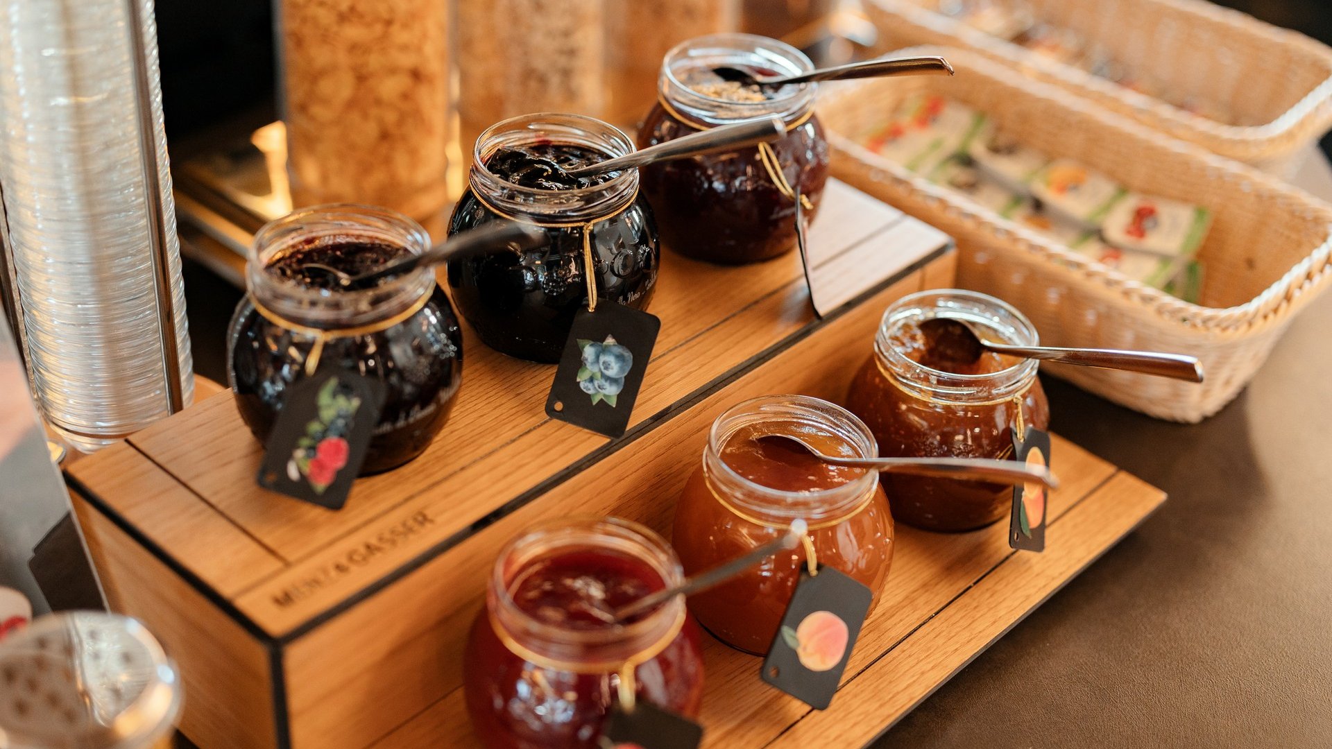 Cuisine at one of the top hotels in Grödnertal with 3 stars Assorted jars of jam with spoons on a wooden stand