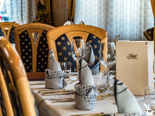 Cuisine at one of the top hotels in Grödnertal with 3 stars Elegant set table with folded napkins and wine glasses in a restaurant