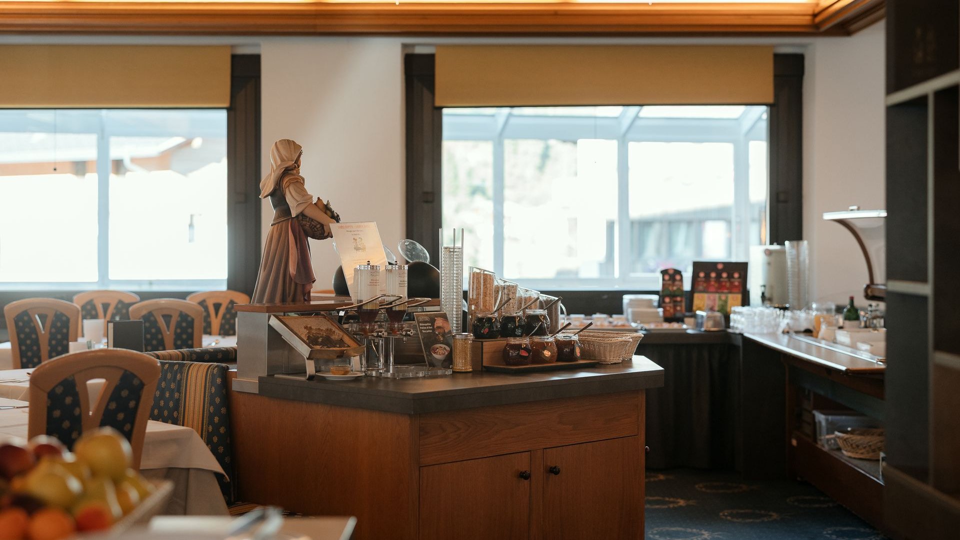 Cuisine at one of the top hotels in Grödnertal with 3 stars Interior view of a cozy breakfast buffet with wooden decor and figurines